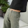 Woman's torso wearing high waist heavy linen pants in green