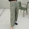 A woman wearing muted green heavy linen wide leg pants