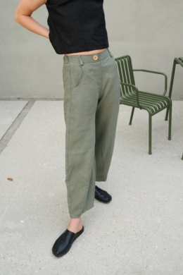 A woman wearing muted green heavy linen wide leg pants