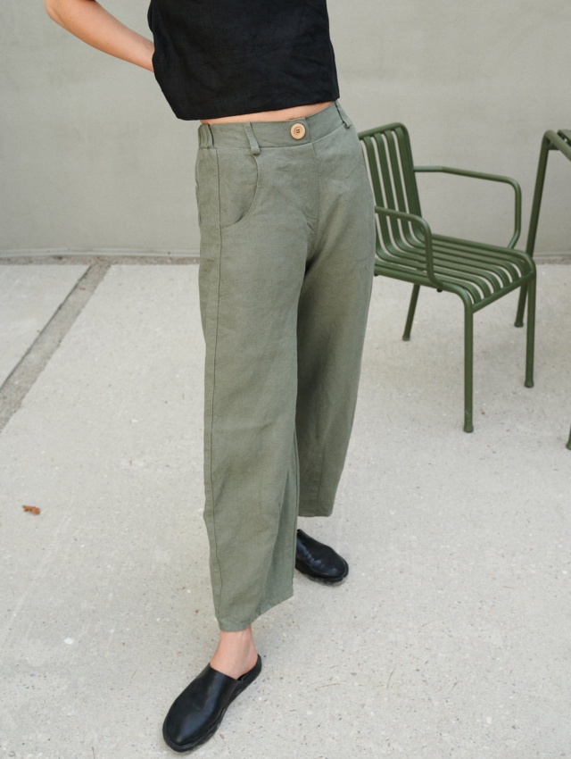 A woman wearing muted green heavy linen wide leg pants