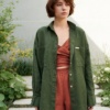 Woman in a loose-fitting green button down linen shirt and terracotta linen top and trousers outfit