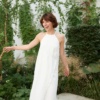 Woman in a long white sleeveless linen dress