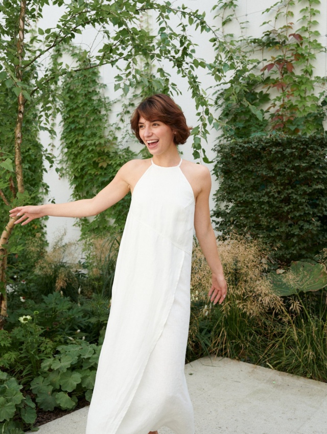 Woman in a long white sleeveless linen dress