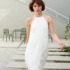 Model wearing a white maxi linen dress with an asymmetrical seam detail