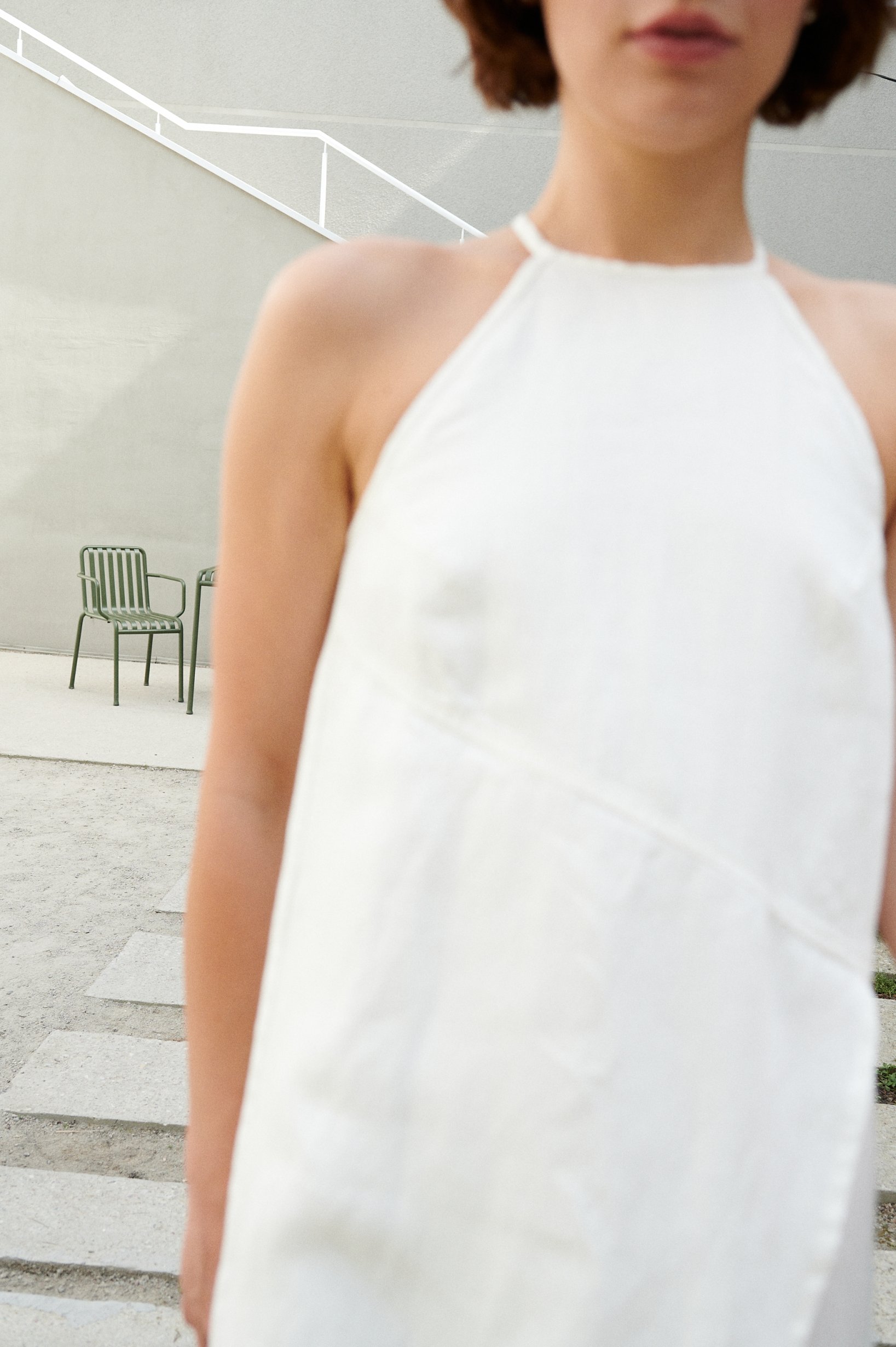 A white sleeveless linen dress with a halter neck