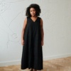 Front of a model in a long black sleeveless linen dress