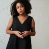 A black linen dress with wide straps and a V neckline