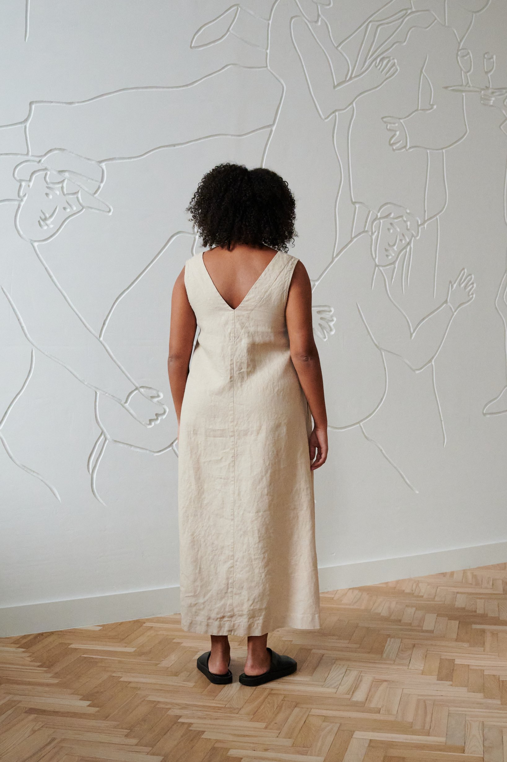 A long sleeveless linen dress with a V neckline in the back