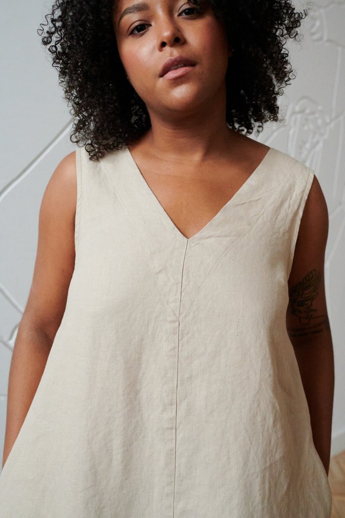 A beige sleeveless linen dress with a V neckline