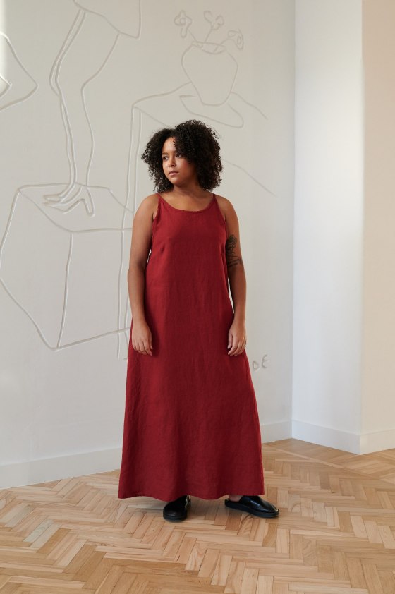 Front of a model in a slightly flared linen maxi dress with spaghetti straps