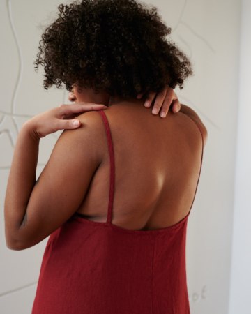Back details of a red linen dress showing spaghetti straps and a low-cut back