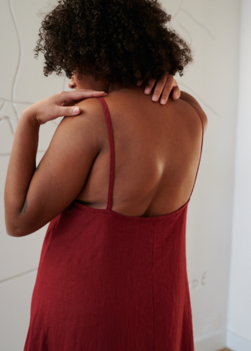 Back details of a red linen dress showing spaghetti straps and a low-cut back