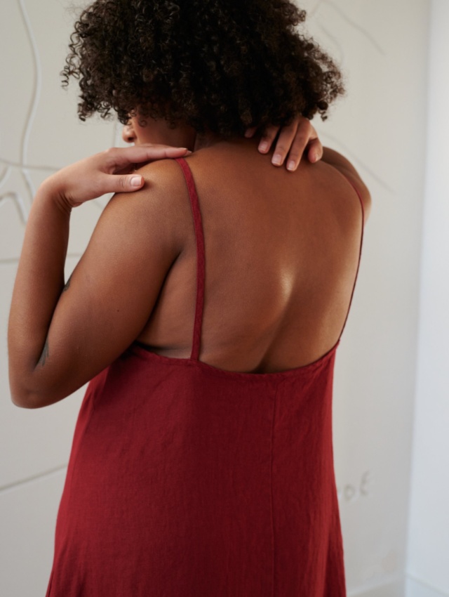 Back details of a red linen dress showing spaghetti straps and a low-cut back