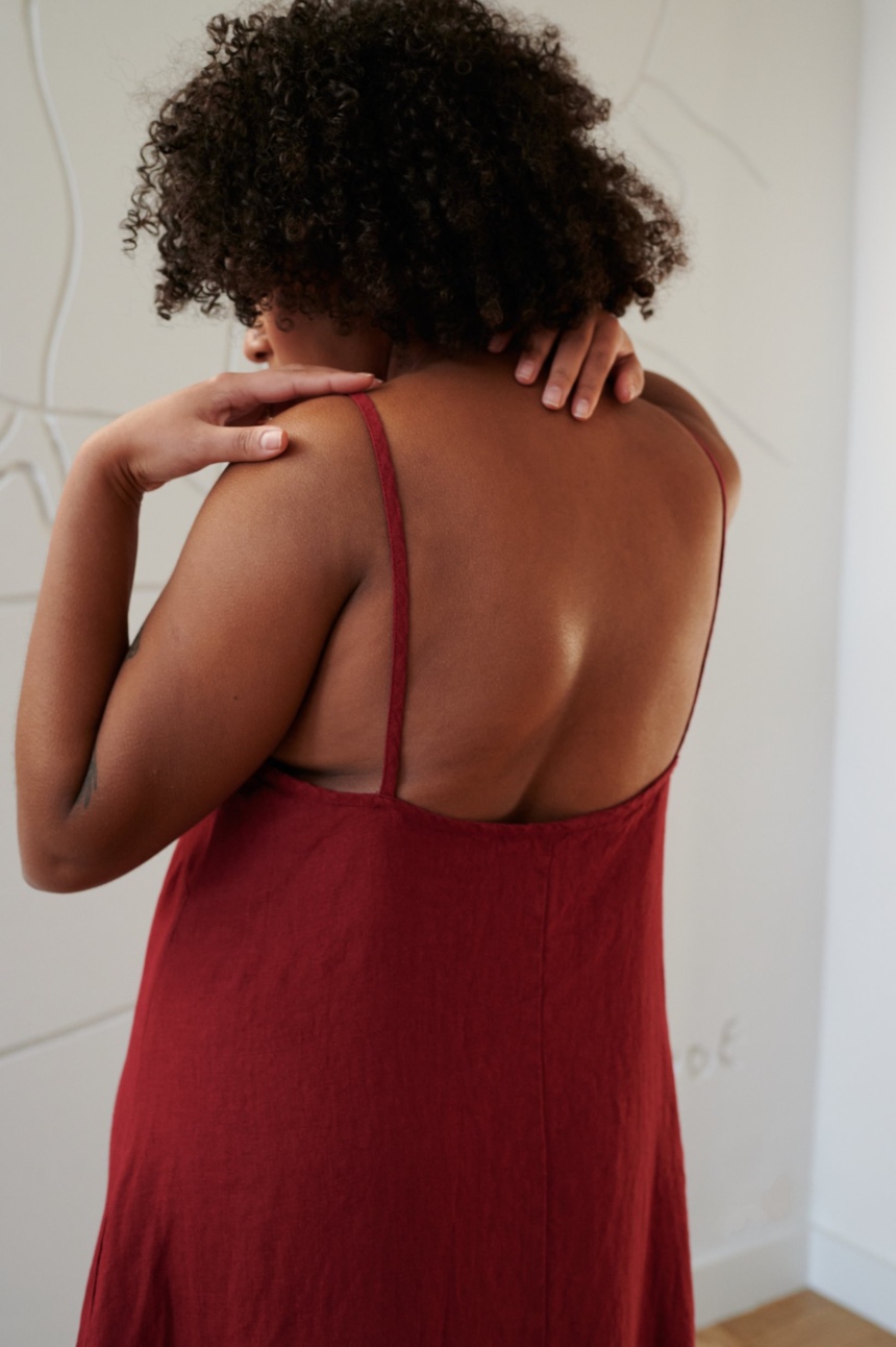 Back details of a red linen dress showing spaghetti straps and a low-cut back