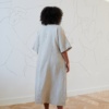 Back of a model in an A-line long linen dress wide sleeves
