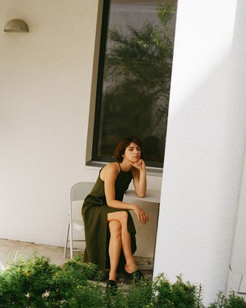 Model sitting while wearing a maxi black linen summer dress