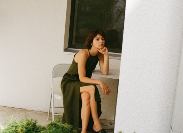 Model sitting while wearing a maxi black linen summer dress