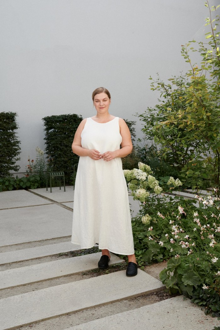 A plus-size model in a milky white linen maxi dress with a round neckline