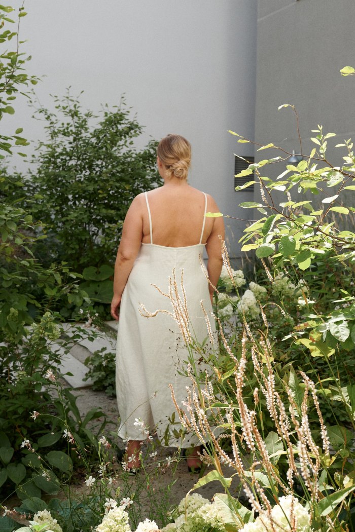 Plus-size model in long linen summer dress with a low-cut back and spaghetti straps