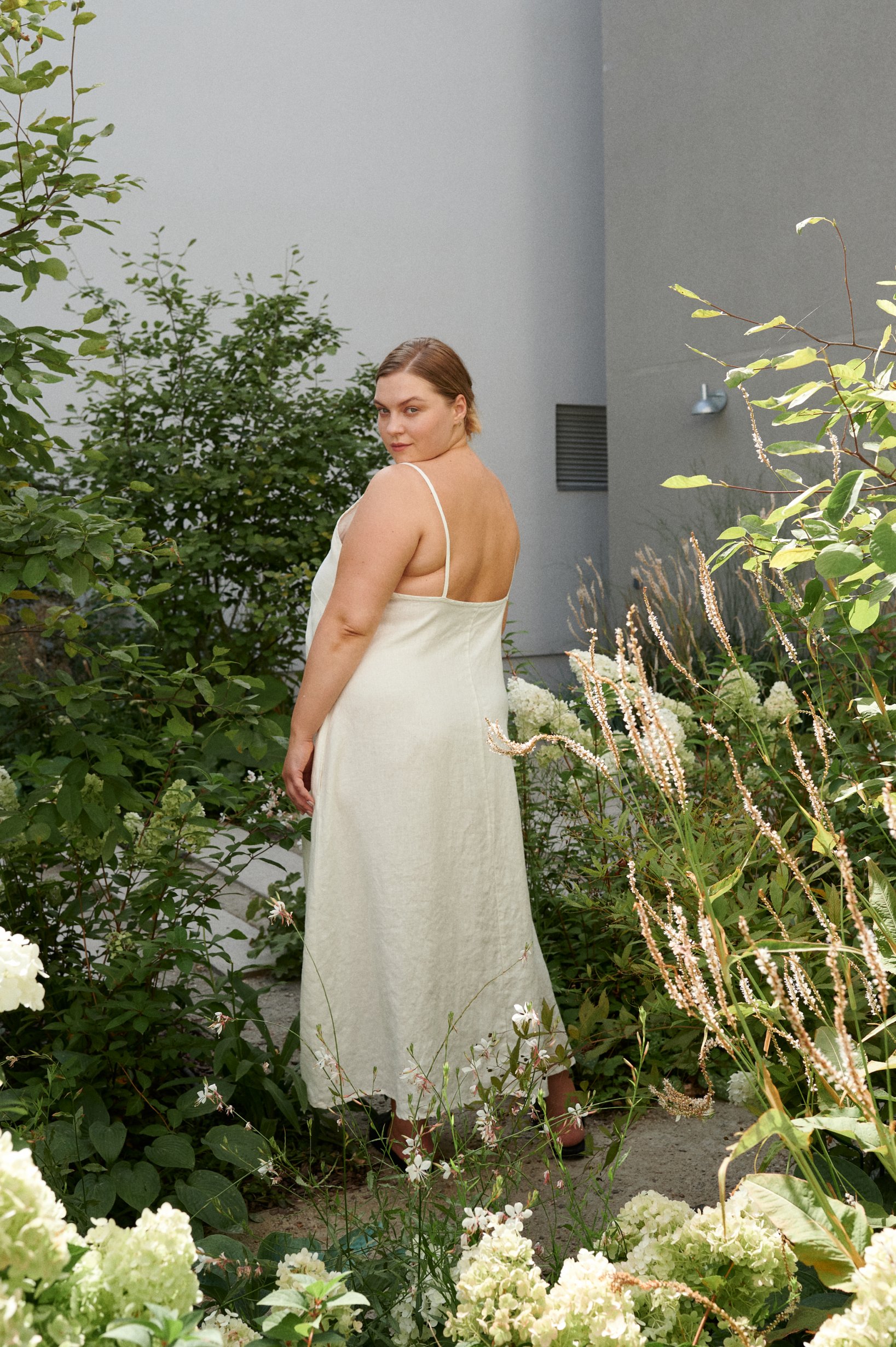 A milky white lightweight maxi linen dress with spaghetti straps and low-cut back