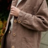 Details of wooden buttons, pockets and cuffs of a brown linen utility jacket
