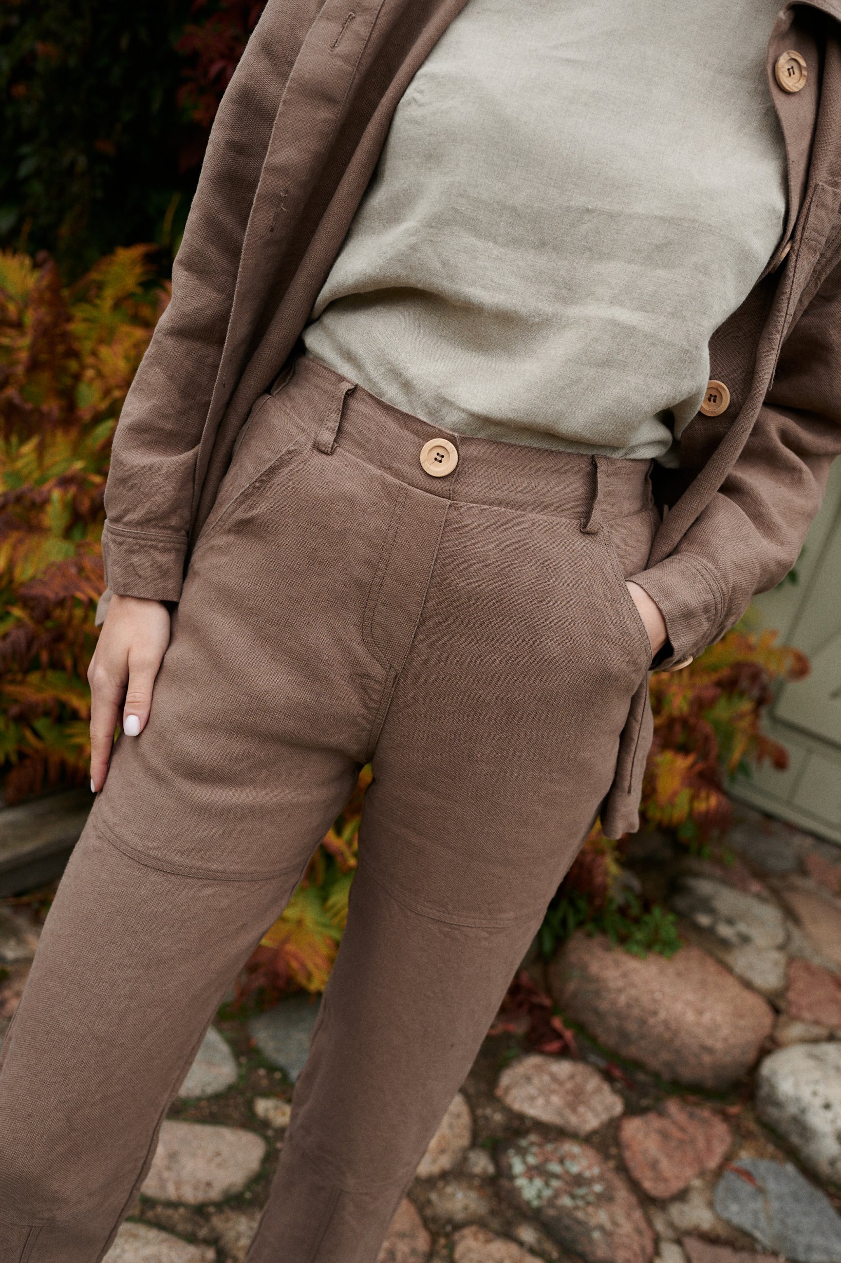 Brown utility linen trousers with a decorative wooden button and size pockets