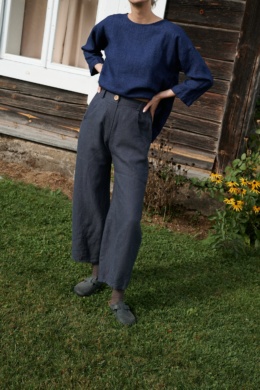 A woman wearing dark grey heavy linen high waist trousers