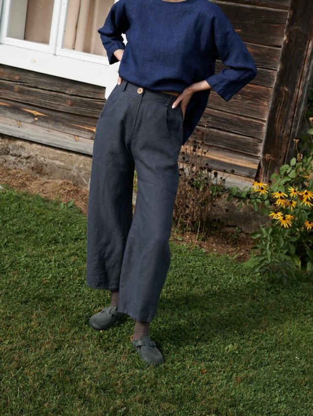 A woman wearing dark grey heavy linen high waist trousers