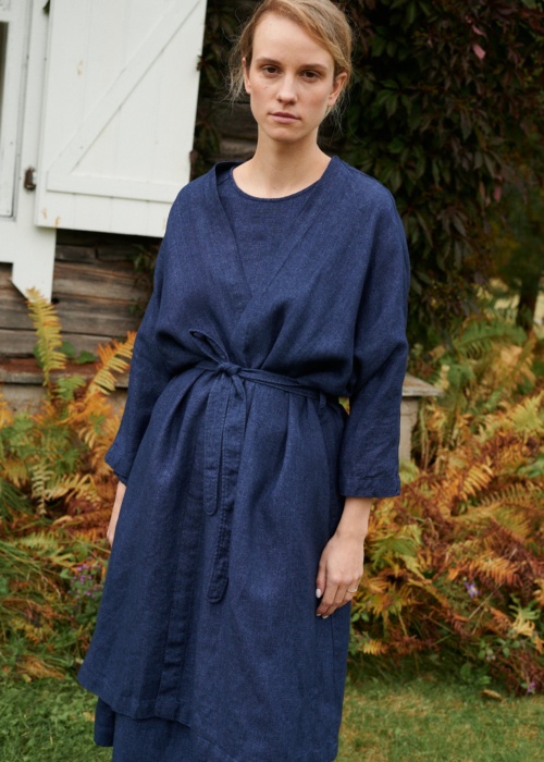 Woman in a navy blue linen wool blend jacket with a belt