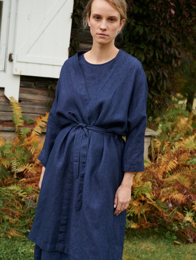 Woman in a navy blue linen wool blend jacket with a belt