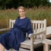 Woman in a navy blue linen wool blend jacket sitting on a bench