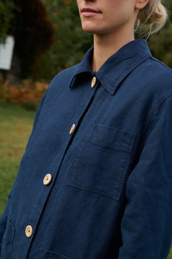 Collar and wooden button details of a blue heavy linen utility jacket