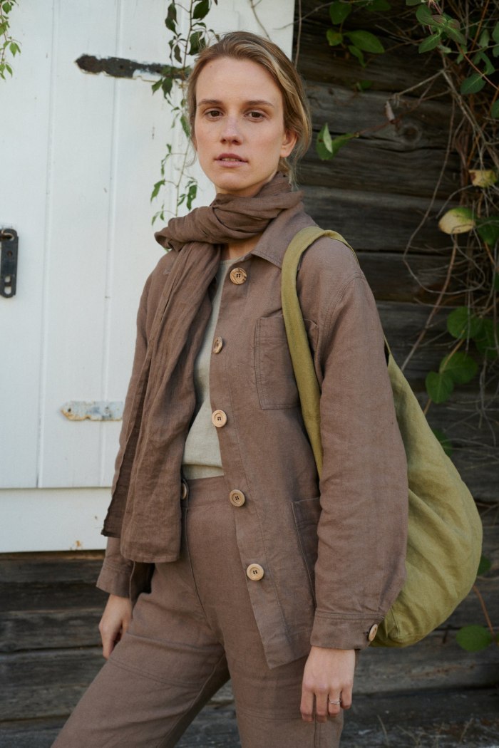 Model wearing an all linen outfit with a linen scarf and bag