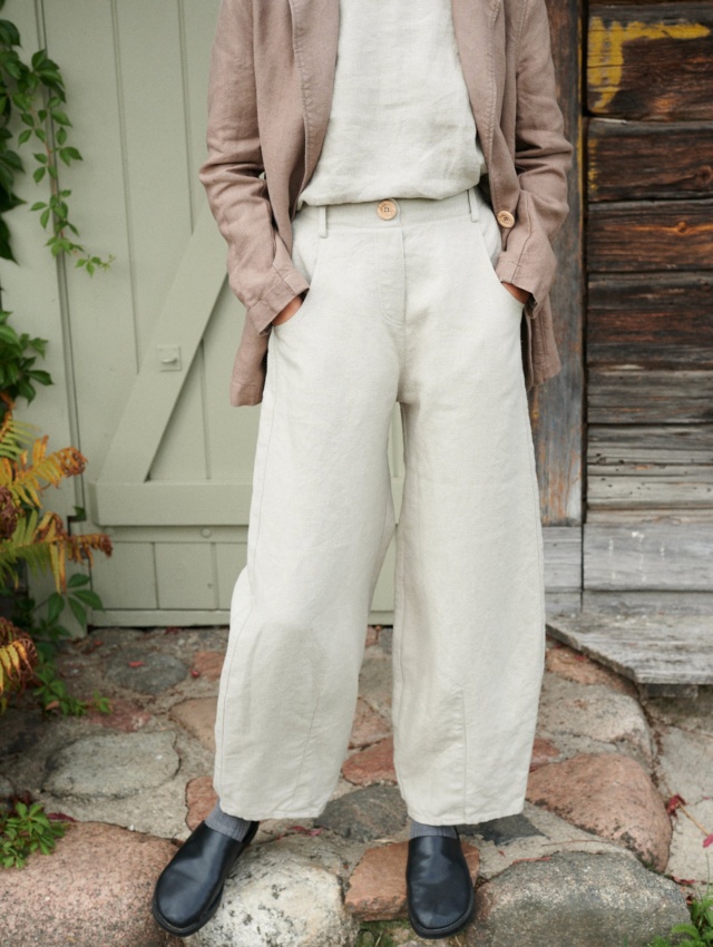 A woman in high waist barrel leg heavy linen trousers