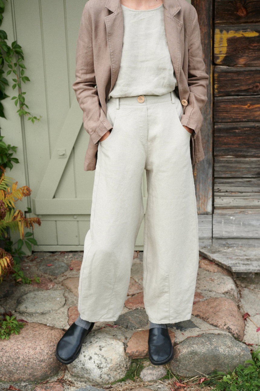 A woman in high waist barrel leg heavy linen trousers