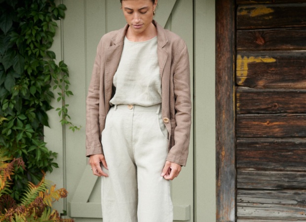 A woman standing in light grey heavy linen trousers