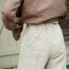 The elasticated back of heavy linen trousers in natural grey