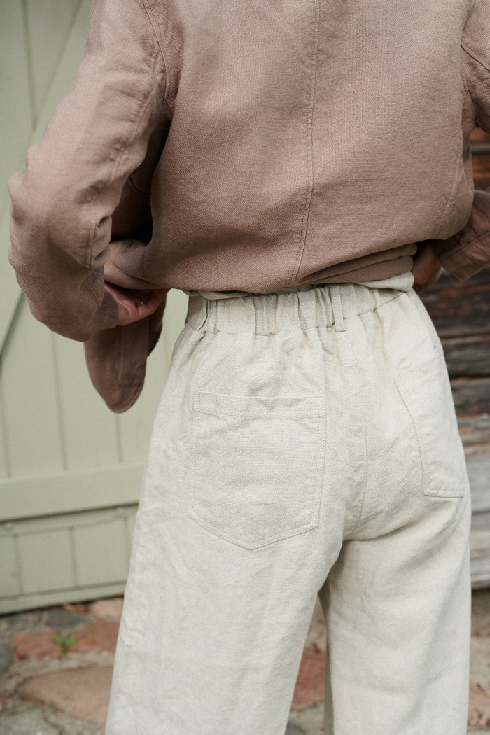 The elasticated back of heavy linen trousers in natural grey