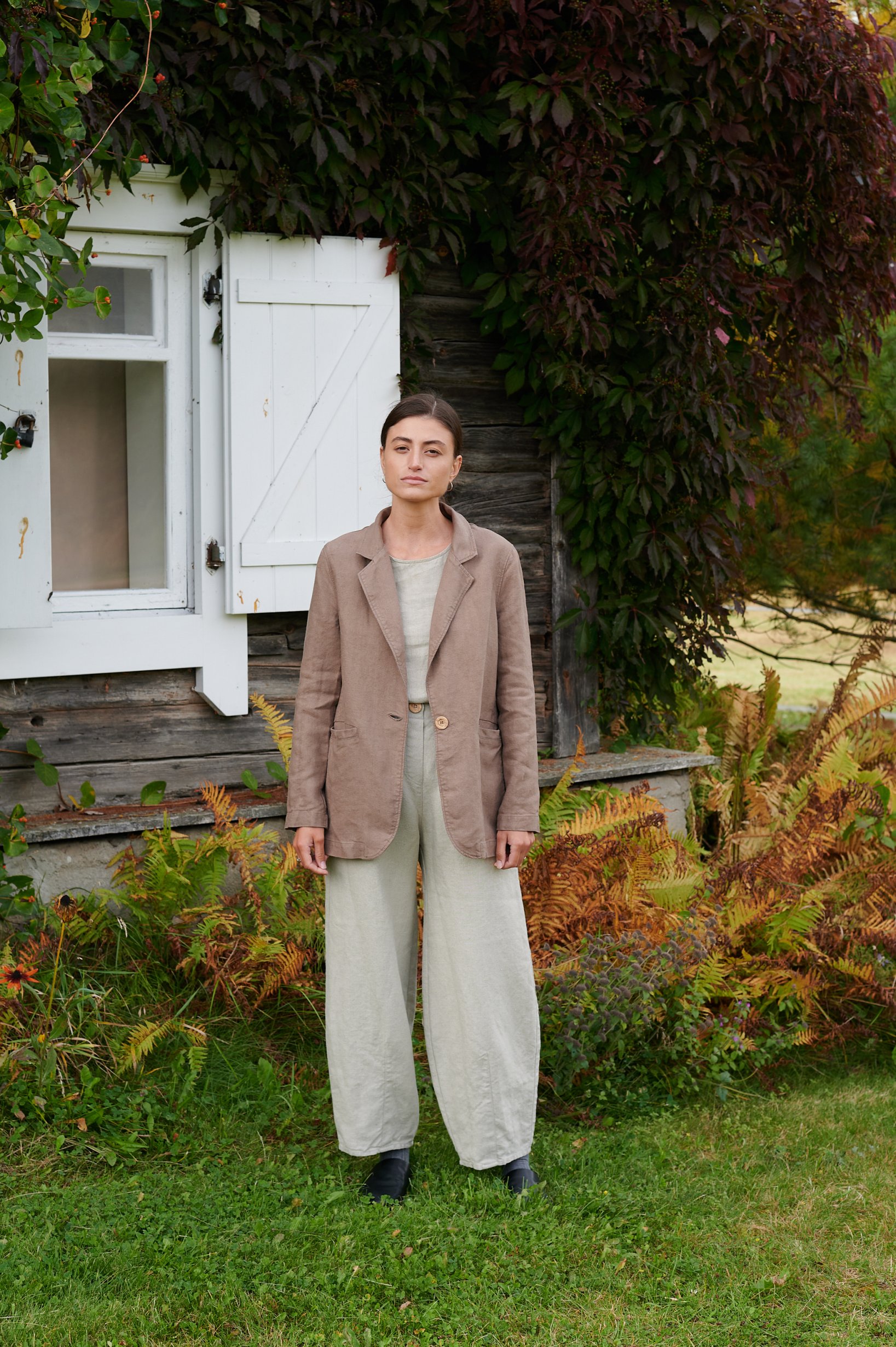 A woman standing in natural heavy linen wide leg pants