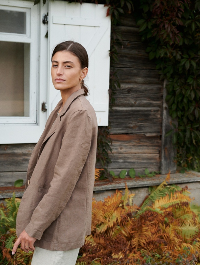 Side view of a model wearing a cacao heavy linen blazer with notch lapels