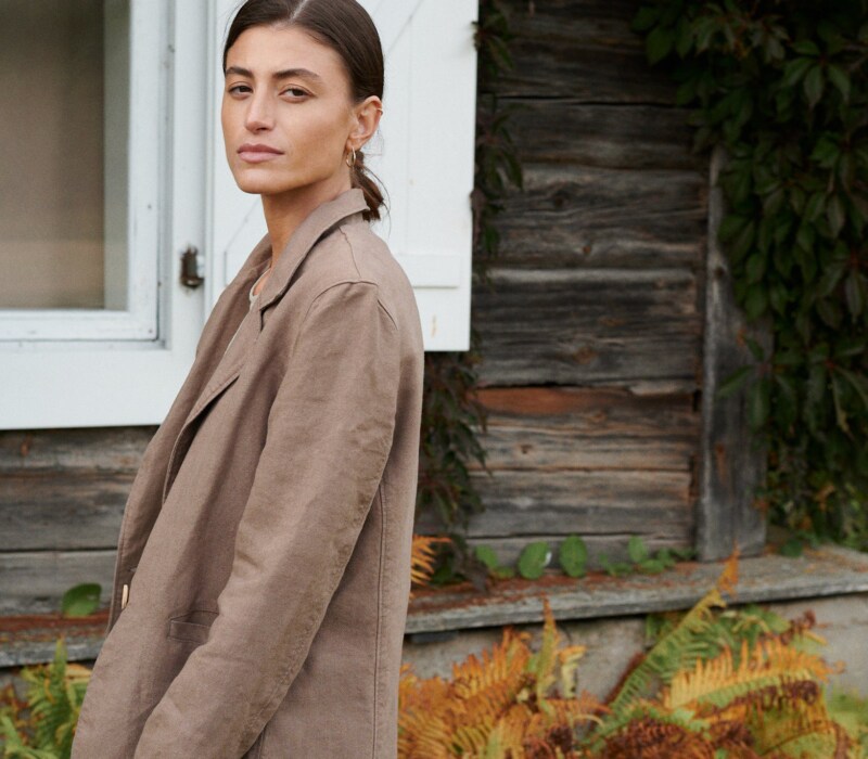 Side view of a model wearing a cacao heavy linen blazer with notch lapels