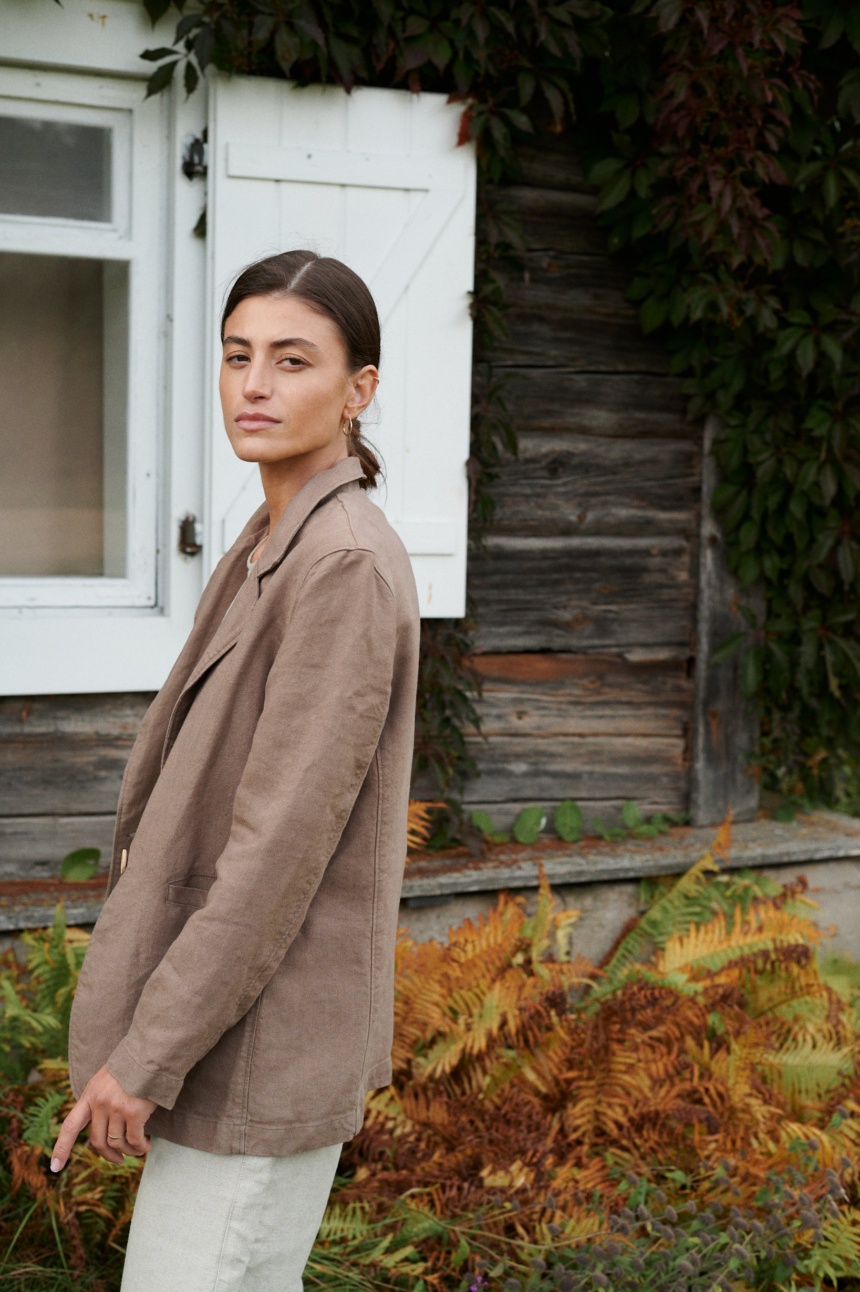 Side view of a model wearing a cacao heavy linen blazer with notch lapels