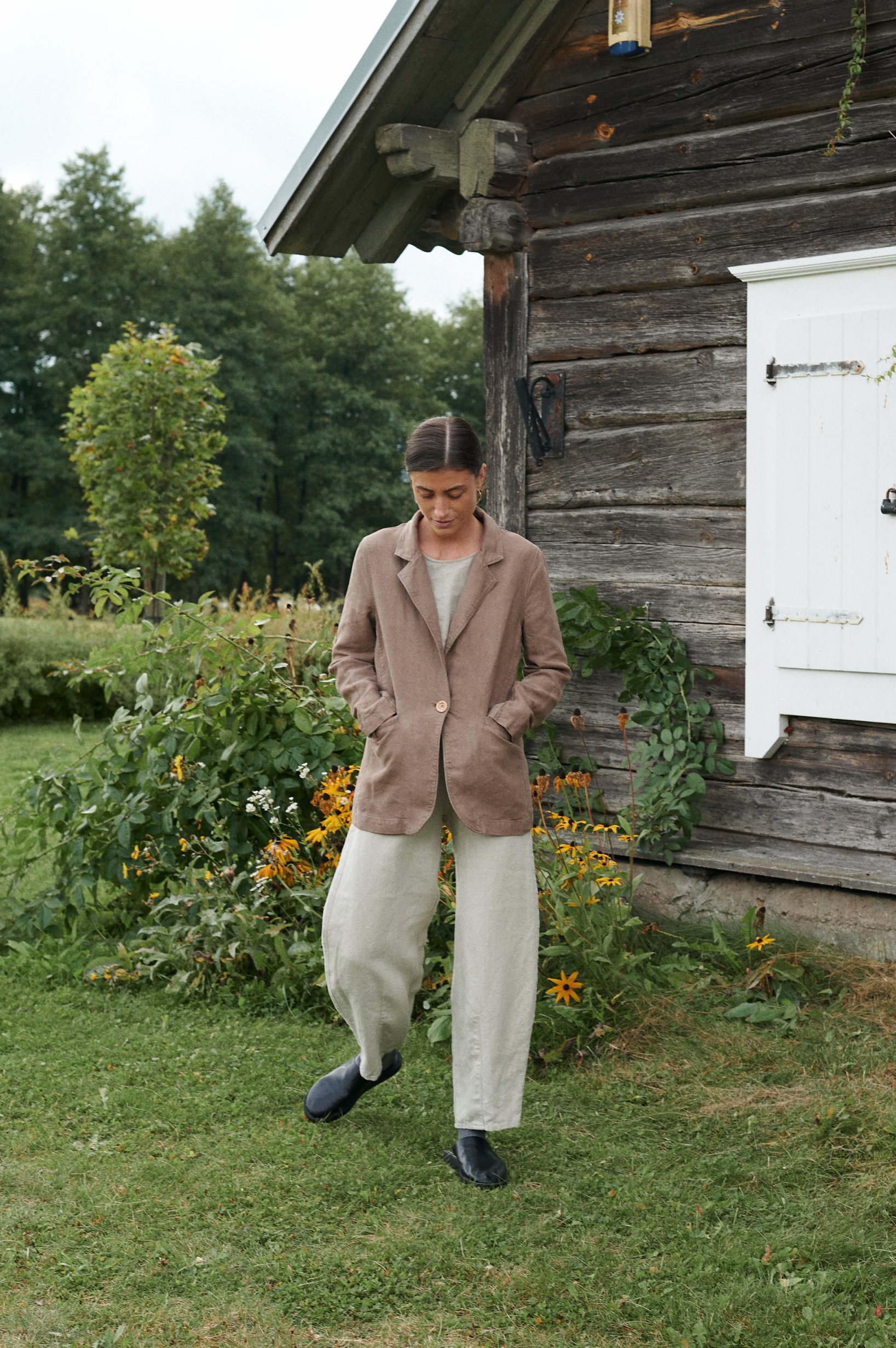A model wearing high waisted natural grey heavy linen trousers
