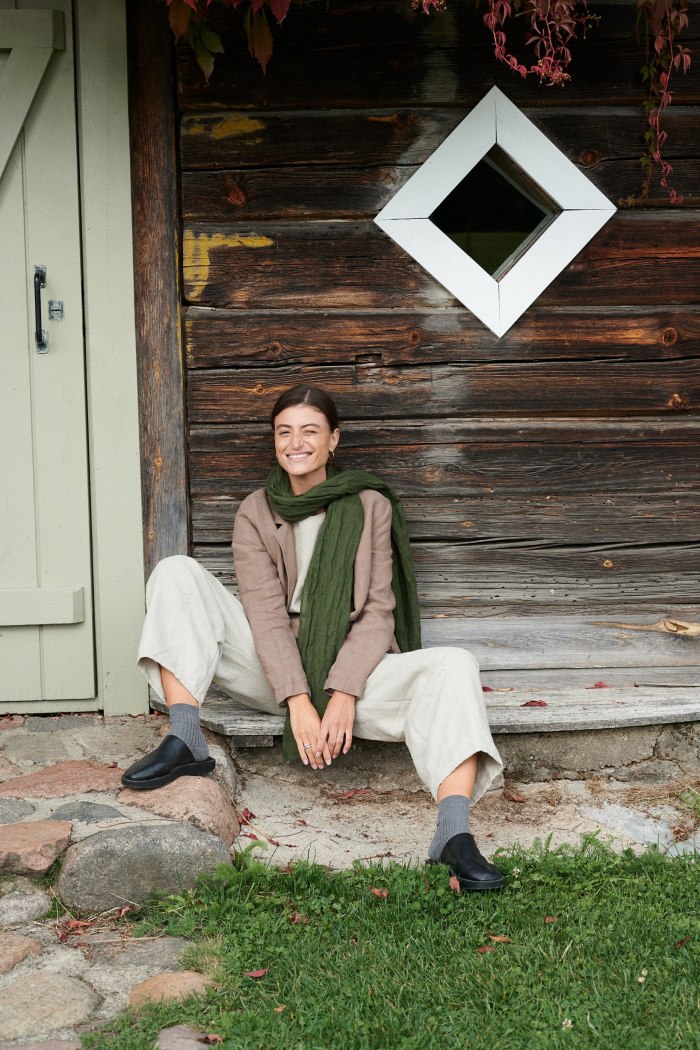 A woman sitting in natural grey heavy linen trousers