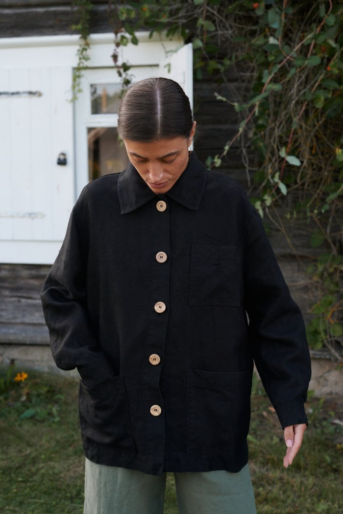 Front of a black linen utility jacket with patch pockets and wooden buttons