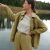 Woman in an unbuttoned green utility linen jacket and top tucked into pants