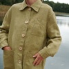 Women in olive green linen outfit near lake