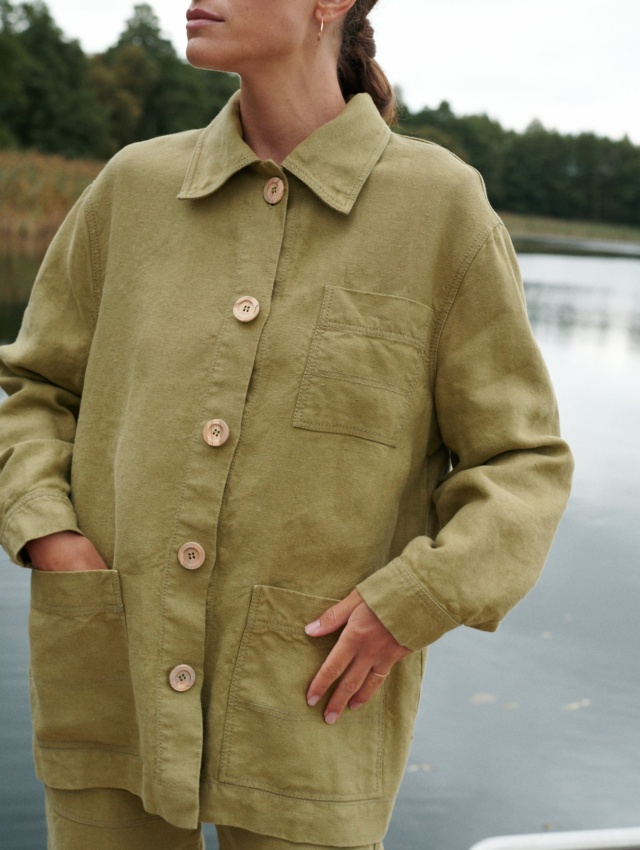 Woman in olive green linen outfit near lake