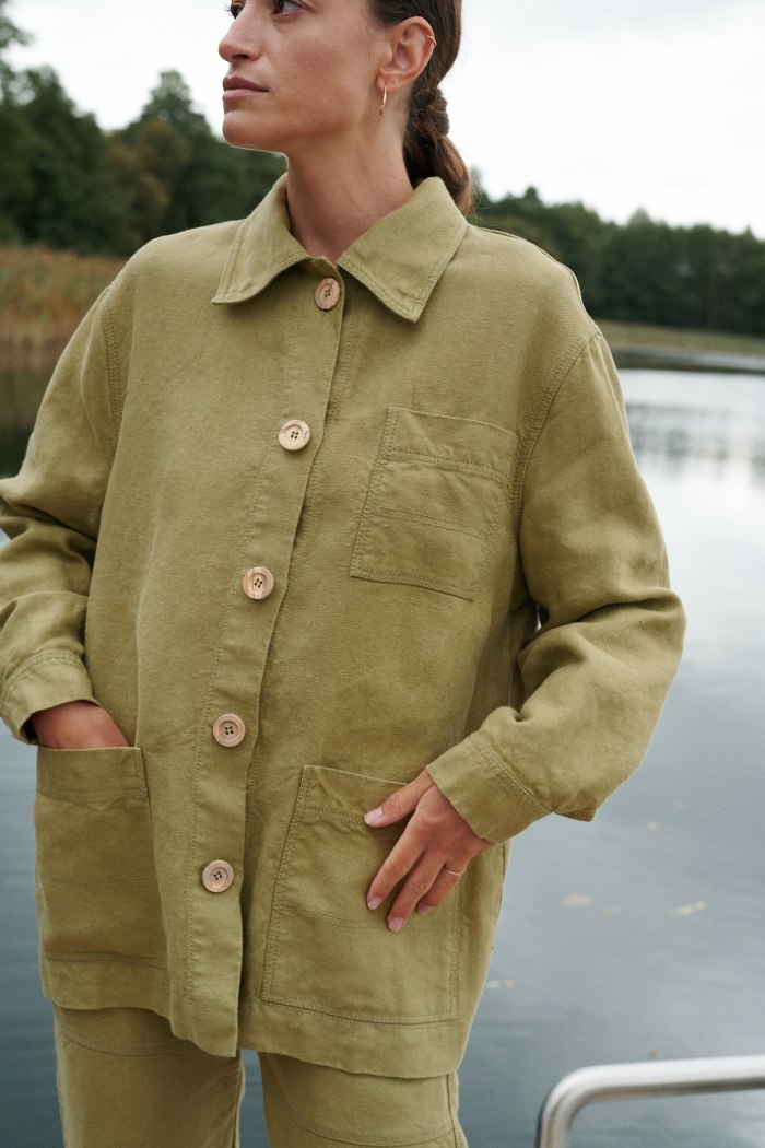 Woman in olive green linen outfit near lake