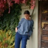 A model in a casual three quarter sleeve blue linen wool blend tunic and navy blue pants